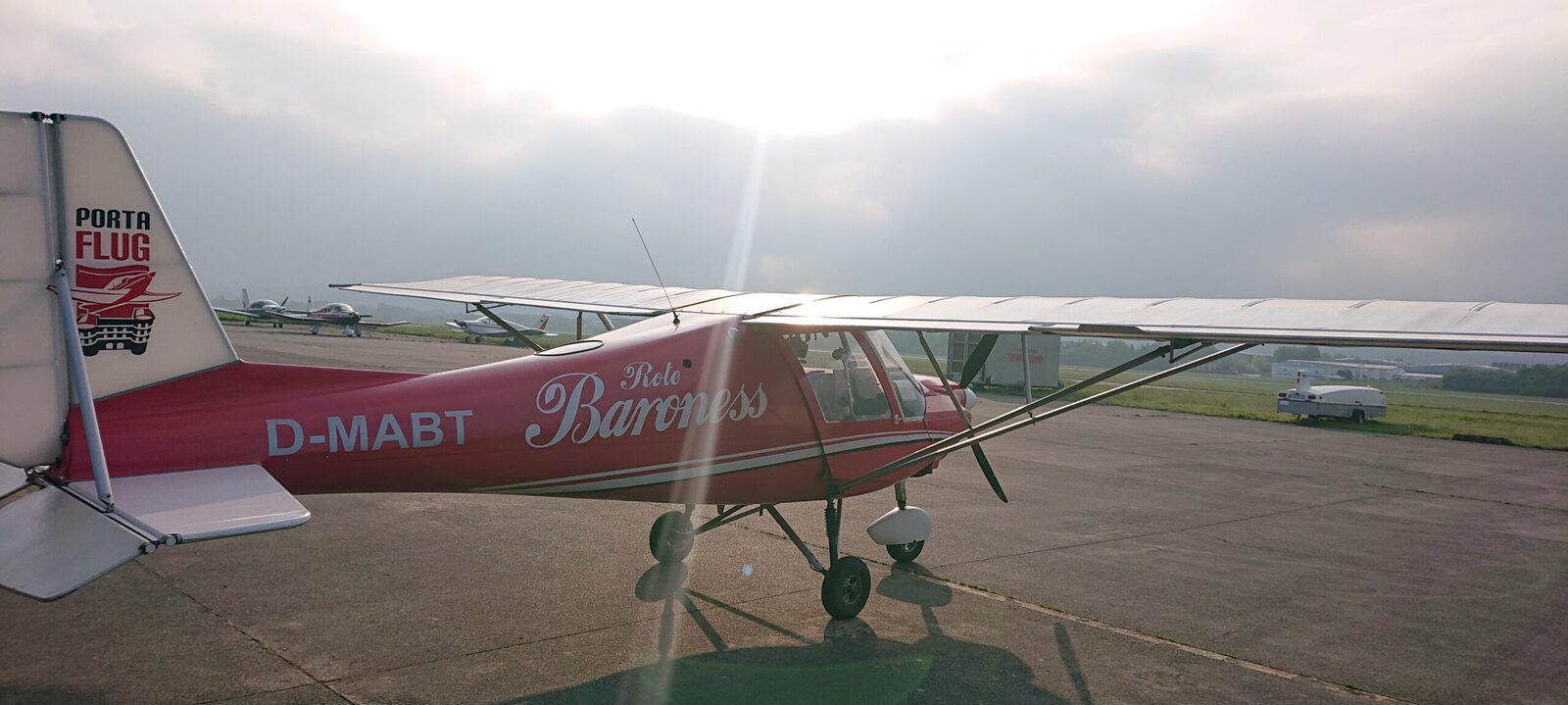 Ein rotes Ultraleichtflugzeug auf dem Rollfeld des Flugplatzes Föhren